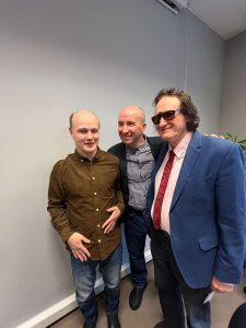 Na zdjęciu widzimy trzech uśmiechniętych mężczyzn stojących obok siebie: Sławek, Mariusz i Grzegorz.