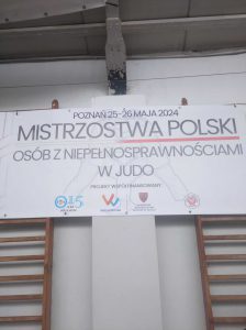 Na zdjęciu znajduje się baner informujący o Mistrzostwach Polski Osób z Niepełnosprawnościami w Judo.